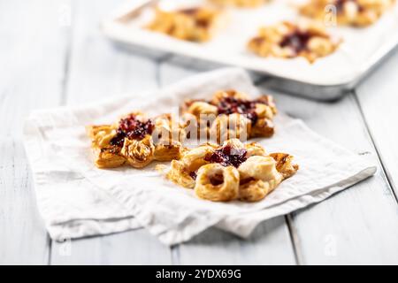 Dolci dolci di pasta sfoglia con marmellata di fragole ripieni di mele caramellate. Foto Stock