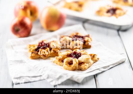 Dolci dolci di pasta sfoglia con marmellata di fragole ripieni di mele caramellate. Foto Stock