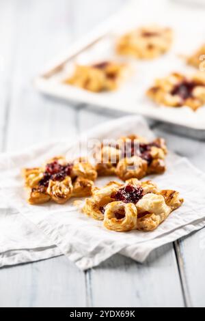 Dolci dolci di pasta sfoglia con marmellata di fragole ripieni di mele caramellate. Foto Stock