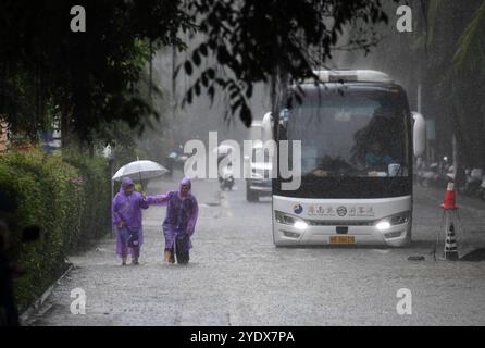 Sanya, la provincia cinese di Hainan. 28 ottobre 2024. Persone e veicoli si spostano attraverso una strada bagnata a Sanya, nella provincia di Hainan, nel sud della Cina, 28 ottobre 2024. Alcune parti della provincia di Hainan hanno subito forti piogge a causa dell'influenza del tifone Trami. Crediti: Zhao Yingquan/Xinhua/Alamy Live News Foto Stock