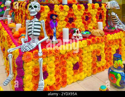 Cabina di vetro con una mostra di scheletri teschi e fiori per la celebrazione del giorno di Halloween dei morti Las Rozas Village outlet shopping Madrid Spagna Foto Stock