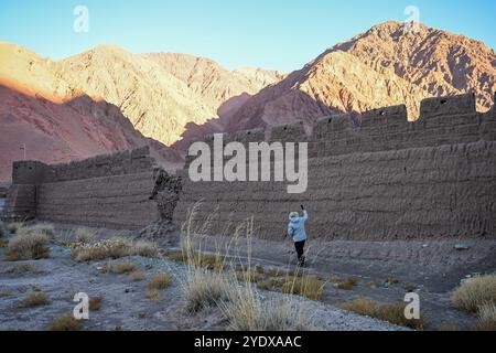 (241028) -- ATUX, 28 ottobre 2024 (Xinhua) -- Un membro di una squadra di spedizione scientifica scatta foto della rovina di un'antica caserma con un telefono cellulare nella città di Muji della contea di Akto, nella prefettura autonoma di Kirgiz di Kizilsu nella regione autonoma di Xinjiang Uygur, nel nord-ovest della Cina, il 21 ottobre 2024. Una spedizione scientifica multidisciplinare di otto giorni è stata lanciata il 19 ottobre a Atux City nello Xinjiang. Durante la spedizione, i ricercatori hanno condotto indagini su antiche strade, siti storici e importanti marchi geografici nella prefettura autonoma di Kizilsu nello Xinjiang. (Xinhua/Ding L Foto Stock