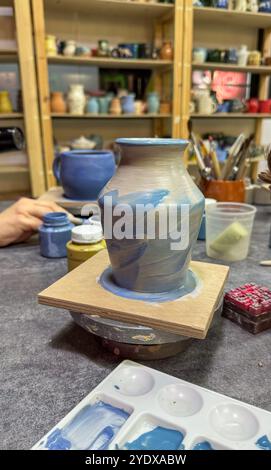 Il processo di pittura di un vaso in ceramica durante una masterclass. Creatività e attenzione ai dettagli in ogni pennellata, per creare un'esclusiva artwor in ceramica Foto Stock