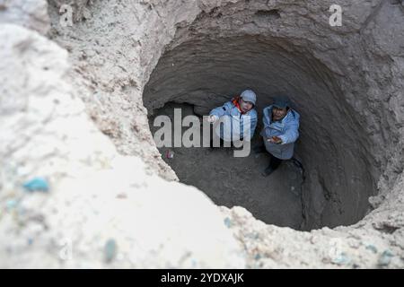 (241028) -- ATUX, 28 ottobre 2024 (Xinhua) -- i membri di una spedizione scientifica controllano le rovine di un'antica residenza nella contea di Wuqia, nella prefettura autonoma di Kizilsu nel nord-ovest della Cina Xinjiang Uygur, 26 ottobre 2024. Una spedizione scientifica multidisciplinare di otto giorni è stata lanciata il 19 ottobre a Atux City nello Xinjiang. Durante la spedizione, i ricercatori hanno condotto indagini su antiche strade, siti storici e importanti marchi geografici nella prefettura autonoma di Kizilsu nello Xinjiang. (Xinhua/Ding lei) Foto Stock