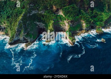 Paesaggio panoramico con rocce e oceano blu con onde in Indonesia. Sopra la vista. Foto Stock