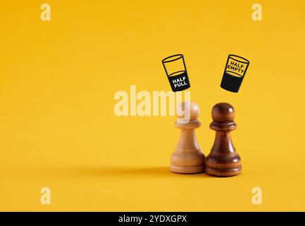 Concetto mezzo vuoto o mezzo pieno. Pensiero o processo decisionale negativo o positivo. Ottimismo o pessimismo. Pedine da scacchi con simboli di vetro su di voi Foto Stock