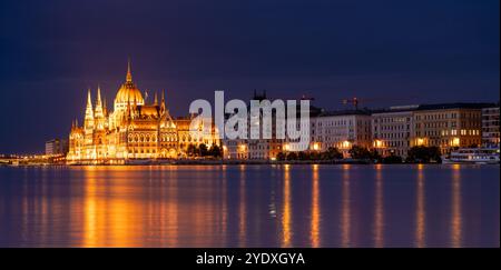 Budapest, Ungheria - 17 settembre 2024: Il Parlamento di Budapest riflette sul Danubio nella notte. Scatto con esposizione notturna prolungata. Foto Stock