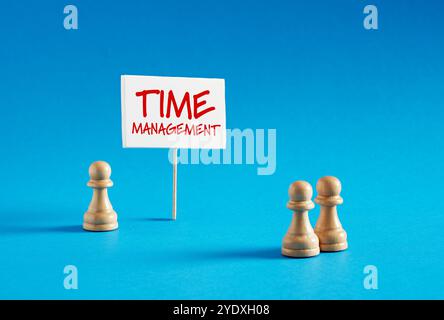 Pedine degli scacchi in piedi accanto allo striscione con la parola Time management. Gestione del tempo e dell'efficienza nel concetto di gestione dei progetti aziendali. Foto Stock