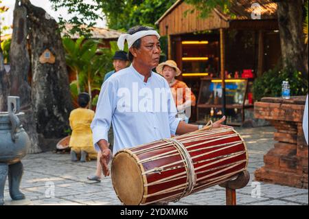 Ritratto di un musicista adulto vietnamita che suona un tamburo tradizionale al po Nagar Cham Towers Festival di Nha Trang in Asia. Nha Trang, Vietnam - 8 agosto 2024 Foto Stock