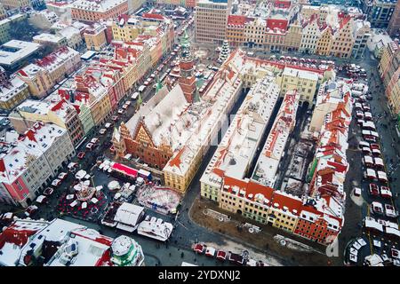 Vista aerea della città europea coperta di neve con edifici dal tetto rosso nella stagione invernale. Mercatino di Natale e strade decorate della città di Breslavia, Polonia Foto Stock