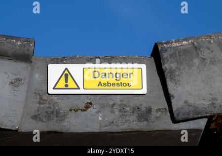 Segnale di avvertimento di amianto su un tetto di una zona industriale, Carlisle, Regno Unito. Foto Stock