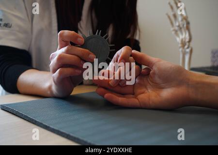 Centro di fisioterapia specializzato in patologie della mano, del gomito e della spalla prima o dopo l'intervento. Test di Weber, discriminazione tattile. Fisioterapia Foto Stock