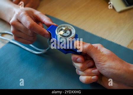 Centro di fisioterapia specializzato in patologie della mano, del gomito e della spalla prima o dopo l'intervento. Prova di resistenza con calibro a mano. Fisioterapia Foto Stock