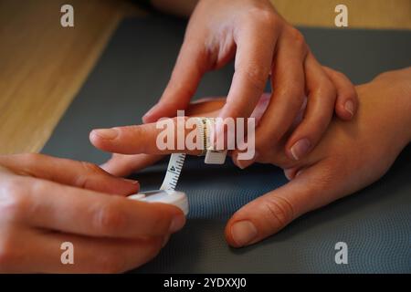 Centro di fisioterapia specializzato in patologie della mano, del gomito e della spalla prima o dopo l'intervento. Centimetro di edema digitale. Fisioterapia Foto Stock