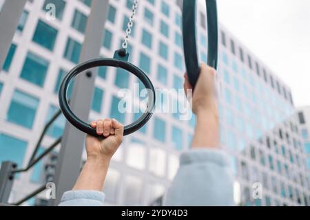 Mani, anello di ginnastica e persona in forma fisica per allenamento, allenamento muscolare o competizione. Primo piano di atleta sospeso, ginnasta forte o acrobata Foto Stock