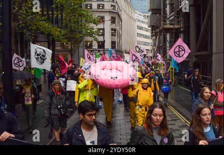 Londra, Regno Unito. 28 ottobre 2024. Gli attivisti di Extinction Rebellion passano davanti al quartier generale dei Lloyd's di Londra mentre danno il via a tre giorni di proteste nella City di Londra, invitando le compagnie assicurative a smettere di assicurare progetti di combustibili fossili. Crediti: Vuk Valcic/Alamy Live News Foto Stock