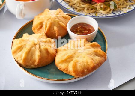 Panini fritti farciti con deliziose torte di carne belyashi sullo sfondo Foto Stock