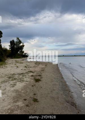 Le calme acque del lago Issyk-Kul riflettono le nuvole e le montagne spettacolari. Silenzio e tranquillità in un'oasi naturale del Kirghizistan. Foto Stock