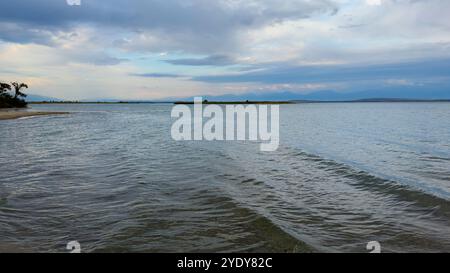 Le calme acque del lago Issyk-Kul riflettono le nuvole e le montagne spettacolari. Silenzio e tranquillità in un'oasi naturale del Kirghizistan. Foto Stock