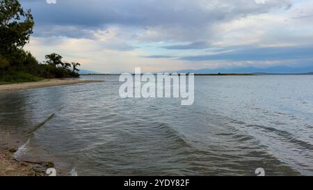 Le calme acque del lago Issyk-Kul riflettono le nuvole e le montagne spettacolari. Silenzio e tranquillità in un'oasi naturale del Kirghizistan. Foto Stock