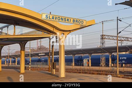 Slavonski Brod, Croazia - 22 ottobre 2024: Cartello della città presso la piattaforma principale della stazione ferroviaria Sunny Morning Autumn. Foto Stock