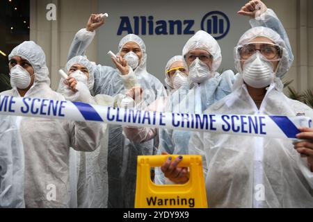 Londra, Inghilterra, Regno Unito. 28 ottobre 2024. Manifestanti in abiti Hazmat, maschere e con video di protesta sulla scena del crimine fuori dagli uffici della compagnia assicurativa Allianz. Extinction Rebellion (XR) cammina per la City di Londra e fermati e dimostra fuori dagli uffici delle compagnie di assicurazione che continuano ad assicurare le compagnie di combustibili fossili nonostante gli avvertimenti di una crisi climatica da parte degli scienziati. I manifestanti credono che se le compagnie assicurative cessassero il loro coinvolgimento con queste compagnie avrebbero lottato per continuare a lavorare con le mie. L'azione è la prima di una protesta di una settimana diretta specificamente a t Foto Stock