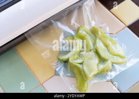 Sigillare gli alimenti freschi con una macchina sigillatrice sottovuoto Foto Stock