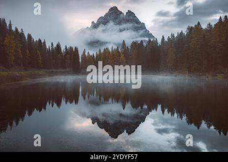 Mattina nebbiosa al Lago d'Antorno con sereni riflessi delle tre Cime di Lavaredo, catturando l'essenza autunnale delle Dolomiti italiane Foto Stock