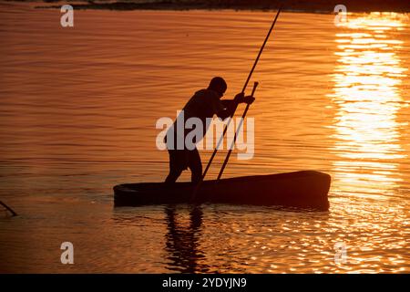 Pescatore in canoa sul fiume Luangwa al tramonto, South Luangwa National Park, Mfuwe, Zambia, Africa Foto Stock