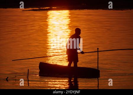 Pescatore in canoa sul fiume Luangwa al tramonto, South Luangwa National Park, Mfuwe, Zambia, Africa Foto Stock