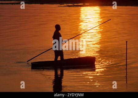 Pescatore in canoa sul fiume Luangwa al tramonto, South Luangwa National Park, Mfuwe, Zambia, Africa Foto Stock