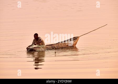 Pescatore in canoa sul fiume Luangwa al tramonto, South Luangwa National Park, Mfuwe, Zambia, Africa Foto Stock