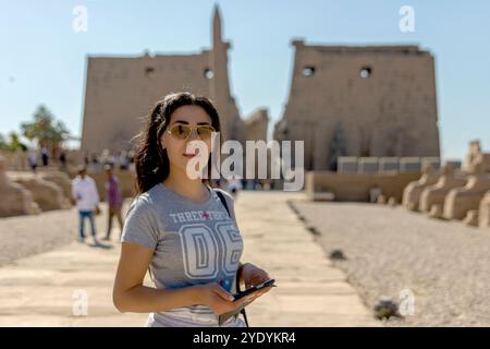 Turista che si gode la bellezza senza tempo del viale delle Sfingi di Luxor che collega il suo tempio a Karnak, collegandolo con la ricca storia dell'antica Egy Foto Stock