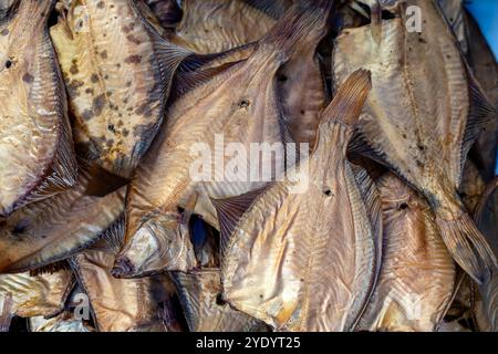 Pesce essiccato in mostra in un vivace mercato, che mette in evidenza la conservazione del pesce locale in vendita. Foto Stock