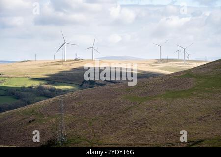 I piloni della linea elettrica e le turbine eoliche si trovano sul monte Mynydd y Betws vicino a Swansea, nel Galles del Sud. Foto Stock