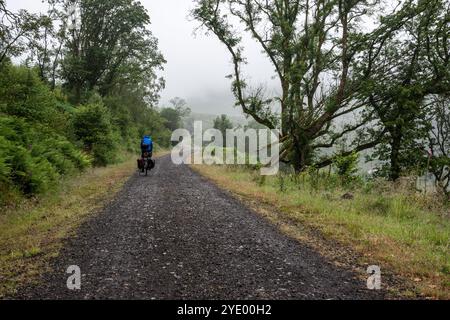 Una touring ciclista scorre attraverso il Brecon Beacons sulla ex Brecon e Merthyr linea ferroviaria, ora parte del ciclo nazionale di instradamento di rete 8. Foto Stock