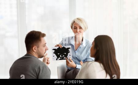 Psicologo Professionista Che Mostra La Coppia Di Test Delle Immagini Inkblot Seduta In Ufficio Foto Stock