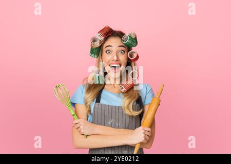 Sorpresa casalinga con curlers apre la bocca larga con shock Foto Stock