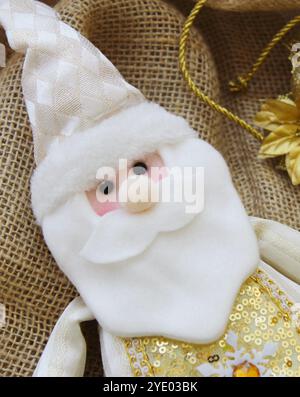 Babbo Natale fatto in feltro ripieno per la decorazione natalizia. Simpatico peluche artigianale per la stagione invernale di dicembre. Fotografia verticale per i social media Foto Stock