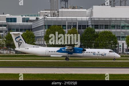 Monaco di Baviera, Germania, 9 aprile 2024: Un taxi della Universal Air De Havilland Canada Dash 8-400 per la pista dell'aeroporto di Monaco. Registrazione 9H-SWW. (Foto di AN Foto Stock