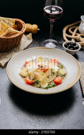 Elegante insalata Caesar con pollo alla griglia, parmigiano, pomodori ciliegini e uova di quaglia bollite Foto Stock