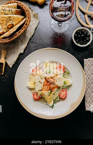 Elegante insalata Caesar con pollo alla griglia, parmigiano, pomodori ciliegini e uova di quaglia bollite Foto Stock