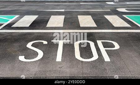 Segnale di stop e passaggio pedonale al piano di un parcheggio. Niente persone. Foto Stock