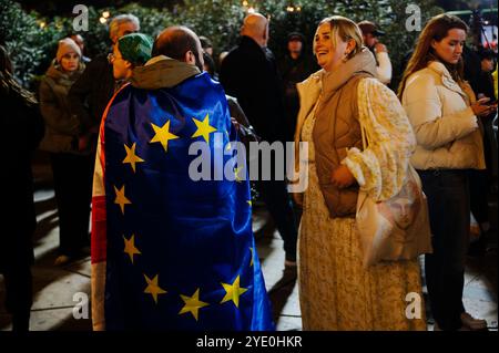 Jan Schmidt-Whitley - manifestazione di opposizione a Tbilisi contro il partito filo-russo Georgian Dream - 28/10/2024 - Georgia (Europa)/Tbilisi/Tbilisi - Un uomo drappeggiato in una bandiera europea si trova fuori dal Parlamento prima della manifestazione. Migliaia di manifestanti si sono riuniti nella capitale georgiana Tbilisi lunedì 28 ottobre in risposta a un appello dell’opposizione filo-occidentale, che si rifiuta di riconoscere i risultati delle elezioni parlamentari, accusando il partito al governo di essere filo-russo e di aver “rubato” il voto. Il presidente Salome Zurabishvili ha denunciato un “totale falsif Foto Stock