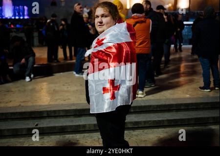 Jan Schmidt-Whitley - manifestazione di opposizione a Tbilisi contro il partito filo-russo del sogno georgiano - 28/10/2024 - Georgia (Europa)/Tbilisi/Tbilisi - Un uomo drappeggiato in una bandiera georgiana si trova davanti al Parlamento prima della manifestazione. Migliaia di manifestanti si sono riuniti nella capitale georgiana Tbilisi lunedì 28 ottobre in risposta a un appello dell’opposizione filo-occidentale, che si rifiuta di riconoscere i risultati delle elezioni parlamentari, accusando il partito al governo di essere filo-russo e di aver “rubato” il voto. Il presidente Salome Zurabishvili ha denunciato un “totale fa” Foto Stock