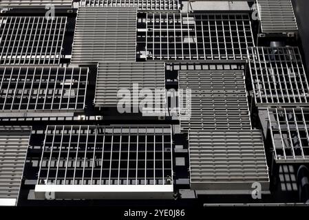 Le pareti di un edificio moderno con prese d'aria in metallo disposte a caso di vari disegni e dimensioni Foto Stock