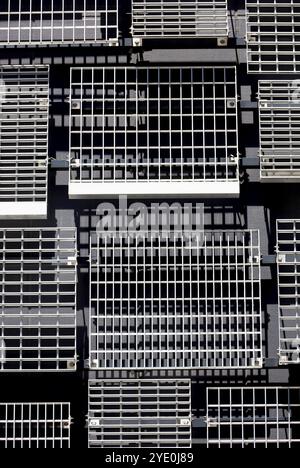 Le pareti di un edificio moderno con prese d'aria in metallo disposte a caso di vari disegni e dimensioni Foto Stock