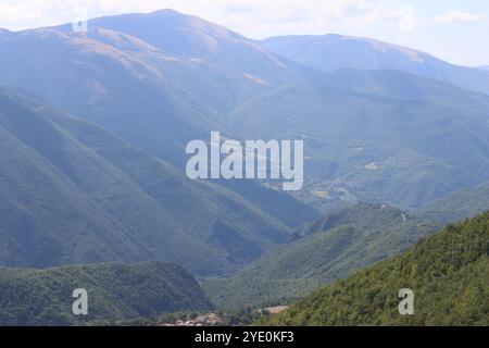 Verdi colline boscose con viste spettacolari, bagnate dal sole estivo in una giornata limpida Foto Stock