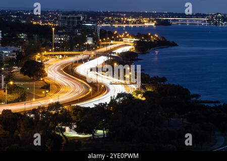 Sentieri leggeri dal traffico intenso su un'autostrada a Perth, Australia di notte durante l'ora di punta. Foto Stock