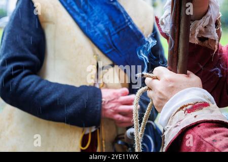 La battaglia di Winwick Civil War Re-Enactor si erge con moschetto matchlock e lino fumante a guardia dei prigionieri scozzesi custoditi nella chiesa di St Oswald Foto Stock